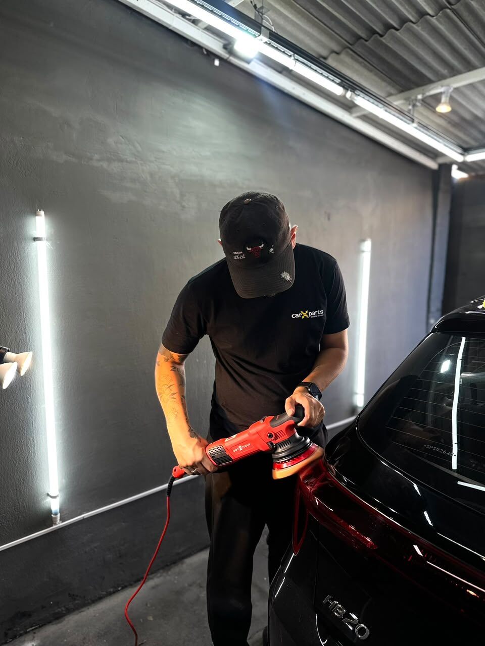 Profissional da Denis Estética Automotiva finalizando o acabamento de um carro